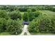 Modern home with a dark facade, sleek lines, and surrounded by lush greenery providing privacy at 11423 Atlantic Rd, Fortville, IN 46040