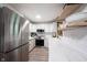 Well-lit kitchen featuring stainless steel appliances, white cabinets, marble countertops and floating shelves at 11423 Atlantic Rd, Fortville, IN 46040