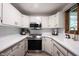 Modern kitchen featuring white cabinets, marble countertops, gold hardware, and stainless steel appliances at 11423 Atlantic Rd, Fortville, IN 46040