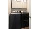 Functional laundry room with modern black washer and dryer, plus overhead cabinets at 11423 Atlantic Rd, Fortville, IN 46040