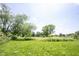 Expansive green field dotted with mature trees, offering a serene and natural setting at 11423 Atlantic Rd, Fortville, IN 46040
