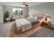 Bright bedroom with large windows, soft carpet, and neutral decor featuring seating area and ceiling fan at 11753 Pawleys Ct, Indianapolis, IN 46235