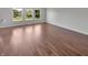 Empty living room featuring hardwood floors, neutral paint, and bright windows with neighborhood views at 11753 Pawleys Ct, Indianapolis, IN 46235