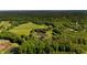 Expansive aerial shot highlighting a house surrounded by nature, complete with a pond and fields at 11875 W 700 S, Columbus, IN 47201