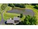 An aerial perspective showcases a two-story home set next to a serene pond and manicured lawn at 11875 W 700 S, Columbus, IN 47201