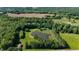 Aerial view showcasing the property's beautiful landscaping, pond, and surrounding wooded area, creating a private oasis at 11875 W 700 S, Columbus, IN 47201