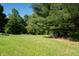 Expansive backyard featuring a lush green lawn, mature trees, and a covered area with plenty of space for outdoor activities at 11875 W 700 S, Columbus, IN 47201