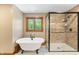 Elegant bathroom showcasing a clawfoot tub and a glass-enclosed shower with tiled walls, exuding luxury at 11875 W 700 S, Columbus, IN 47201