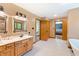 Bright bathroom features a double sink vanity, wood cabinets, tile floor and a separate entry to the bedroom at 11875 W 700 S, Columbus, IN 47201