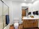 Well-lit bathroom features a glass door shower, toilet and a wooden vanity with ample counter space at 11875 W 700 S, Columbus, IN 47201