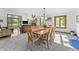Open-concept living and dining area with a stone fireplace, comfortable seating, and a light-filled dining table at 11875 W 700 S, Columbus, IN 47201