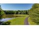 Long driveway winding through a lush green lawn to a beautiful home with a large pond at 11875 W 700 S, Columbus, IN 47201
