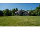 Beautiful two-story home with expansive green lawn, stone chimney, and lush, mature trees at 11875 W 700 S, Columbus, IN 47201