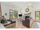Bright living room with stone fireplace, large windows offering views, and plush seating, perfect for relaxing and entertaining at 11875 W 700 S, Columbus, IN 47201