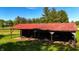 Open-sided outbuilding and surrounding greenery, perfect for storage or hobby space with a vintage aesthetic at 11875 W 700 S, Columbus, IN 47201