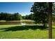 Picturesque view from the porch overlooking a serene pond and lush greenery, offering a tranquil escape at 11875 W 700 S, Columbus, IN 47201
