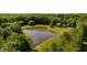 Aerial shot of a house and pond surrounded by trees and a manicured lawn at 11875 W 700 S, Columbus, IN 47201