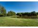 Picturesque pond with vibrant green surroundings, walking path, and lush trees under a clear blue sky at 11875 W 700 S, Columbus, IN 47201