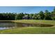 Scenic view of a home nestled by a pond with lush greenery, reflecting the clear blue sky at 11875 W 700 S, Columbus, IN 47201
