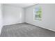 Bright bedroom featuring a large window for natural light and plush, gray carpeting at 12250 Longstraw Dr, Indianapolis, IN 46236