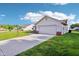 Exterior view showcasing the home's two-car garage and well-kept lawn at 12250 Longstraw Dr, Indianapolis, IN 46236