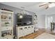 Living room featuring a large television, shelving for storage, and hardwood floors at 1281 Jesse Ct, Greenwood, IN 46143