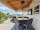 Inviting covered patio featuring ceiling fans, outdoor television, and dining set overlooking the lush backyard at 1281 Jesse Ct, Greenwood, IN 46143