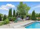 Landscaped backyard area with inviting round daybed and egg chair, surrounding a sparkling pool at 1281 Jesse Ct, Greenwood, IN 46143