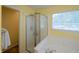 Bright bathroom featuring a glass-enclosed shower, soaking tub, and window with blinds at 13271 Aquamarine Dr, Carmel, IN 46033