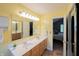 Well-lit bathroom with double sinks, light wood cabinets, large mirror, and tile floor at 13271 Aquamarine Dr, Carmel, IN 46033