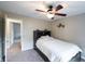 Bright bedroom with a ceiling fan, headboard shelving, and an open doorway to another room at 13271 Aquamarine Dr, Carmel, IN 46033