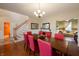 Inviting dining area with hardwood floors, a long table, and a view leading to the living room and stairs at 13271 Aquamarine Dr, Carmel, IN 46033