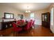 Formal dining room featuring hardwood floors, a dark wood table with red chairs, and a sideboard at 13271 Aquamarine Dr, Carmel, IN 46033