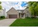 Charming two-story brick home with a well-manicured lawn, attached garage, and inviting front porch at 13271 Aquamarine Dr, Carmel, IN 46033