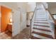 Hallway with stairs, tile floor, closet, and view of the adjacent orange walled bathroom at 13271 Aquamarine Dr, Carmel, IN 46033