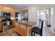 Bright kitchen with wooden cabinets, stainless steel appliances, and a gray countertop island with an adjacent chair at 13271 Aquamarine Dr, Carmel, IN 46033
