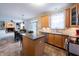Open-concept kitchen with wooden cabinets, stainless steel appliances, island, tile floors connecting to the living area at 13271 Aquamarine Dr, Carmel, IN 46033