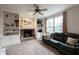 Cozy living room with built-in bookshelves, fireplace, plush carpet, and a comfortable leather sofa at 13271 Aquamarine Dr, Carmel, IN 46033