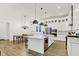 Open kitchen with a large island, stainless steel appliances, and dining area with modern chandelier at 1364 Chatham Hills Blvd, Westfield, IN 46074