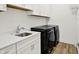 Modern laundry room with black appliances, stylish sink, and white cabinets at 1364 Chatham Hills Blvd, Westfield, IN 46074