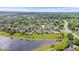 Expansive aerial view of a residential community featuring well-maintained lawns, mature trees, and a serene pond at 14711 Macduff Dr, Noblesville, IN 46062