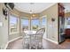 Bright breakfast nook features a white table and chairs, with ample natural light from surrounding windows at 14711 Macduff Dr, Noblesville, IN 46062