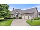 Beautiful brick home featuring a three-car garage, landscaped front yard, and stone entryway at 14711 Macduff Dr, Noblesville, IN 46062