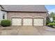 Close up of a three car garage with carriage style doors and mature landscaping at 14711 Macduff Dr, Noblesville, IN 46062