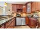 Convenient wet bar featuring stainless steel appliances, granite countertops, and dark wood cabinets offers a sleek entertaining space at 14711 Macduff Dr, Noblesville, IN 46062