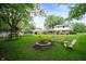 Large backyard with a fire pit, lawn chairs, and lush greenery creating an inviting outdoor space at 1495 E 240 N, Anderson, IN 46012