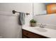Bathroom featuring a dark wood vanity with a white sink, a mirror, and white-tiled walls at 1495 E 240 N, Anderson, IN 46012