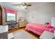 Bright bedroom features hardwood floors, a pink bedspread, and a window with pink valance at 1495 E 240 N, Anderson, IN 46012