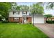 Charming two-story home with brick facade, white siding, attached garage, and well-maintained lawn at 1495 E 240 N, Anderson, IN 46012