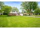 Beautiful two-story home with a well-manicured lawn, mature trees, and a welcoming residential street at 1495 E 240 N, Anderson, IN 46012